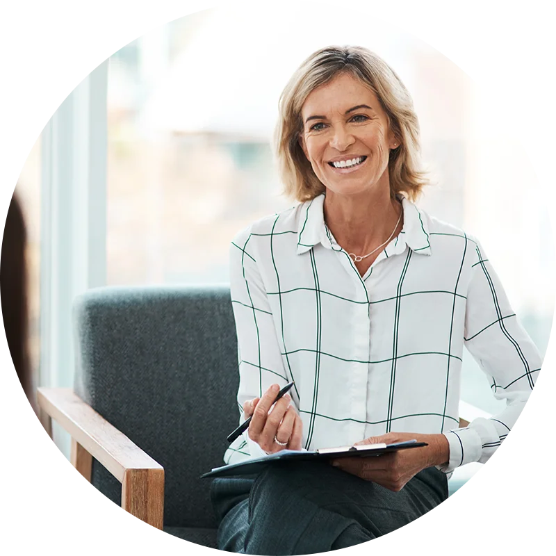 A therapist takes notes and smiles during a session with a new client in the addiction treatment program at Juniper Grove Recovery.