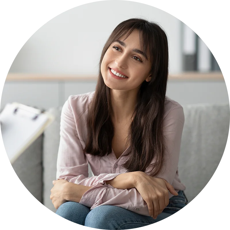 A young woman sits and smiles at her therapist while participating in therapy for co-occurring disorders at Juniper Grove Recovery.