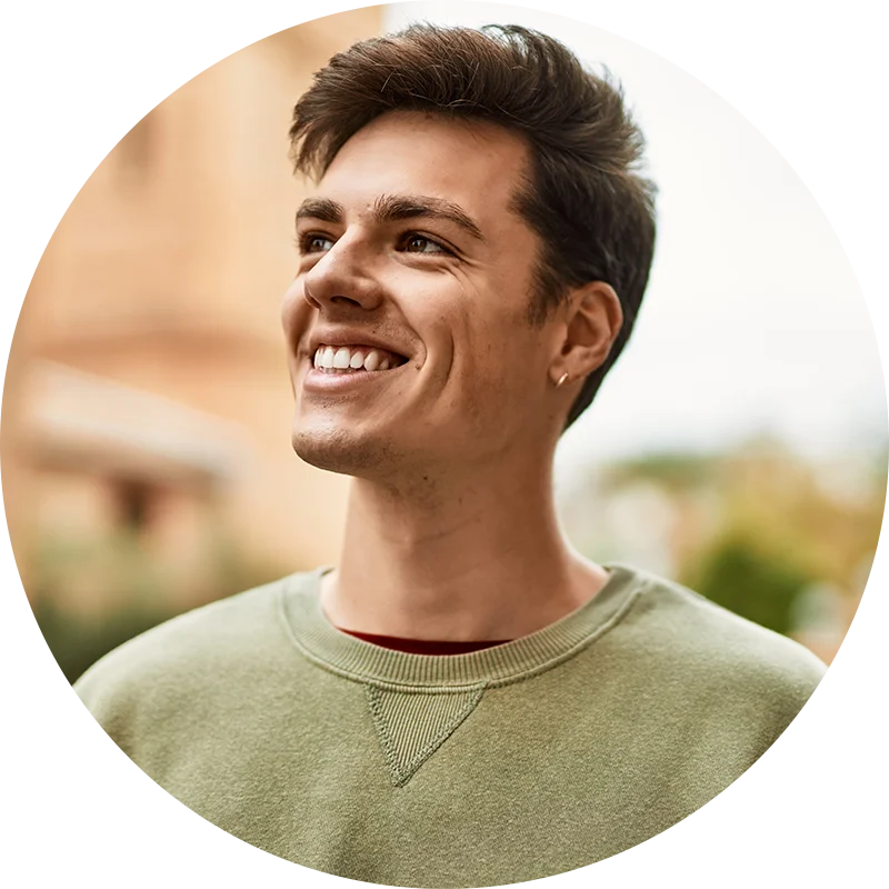 A man looks to the side and smiles widely. He is enjoying life after addiction treatment at Juniper Grove Recovery.