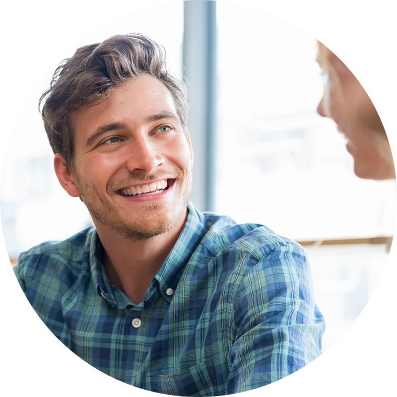 A man smiles at his therapist while participating in a therapy program at Juniper Grove Recovery.